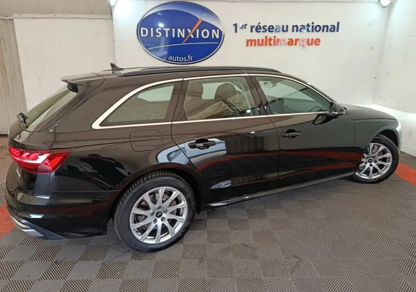Audi A4 35 TFSI Business Line noire vue de profil côté droit dans un showroom avec jantes argentées.