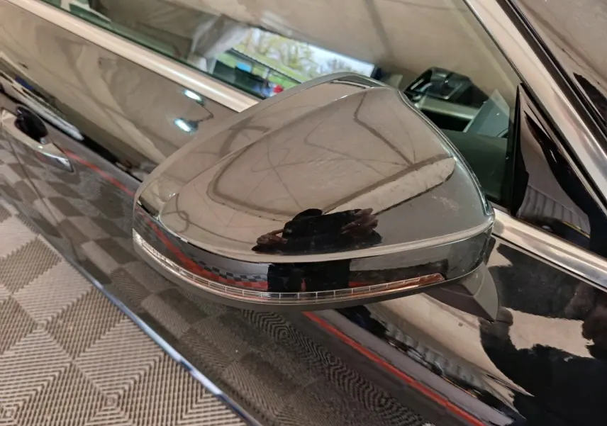 Gros plan sur le rétroviseur côté gauche noir brillant de l'Audi A4 35 TFSI 2024 avec clignotant intégré.