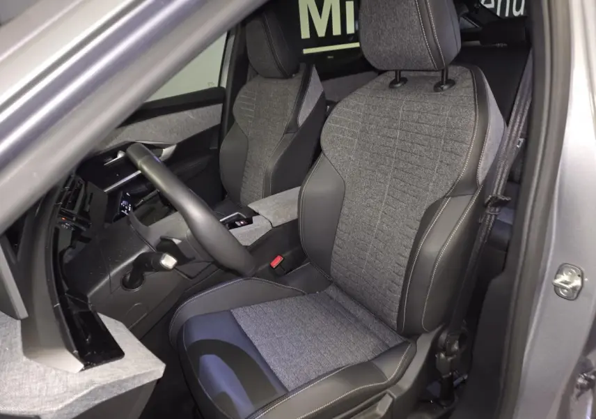 Vue intérieure côté conducteur du Peugeot 3008 gris 2025, sièges tissu et cuir avec surpiqûres Quartz.