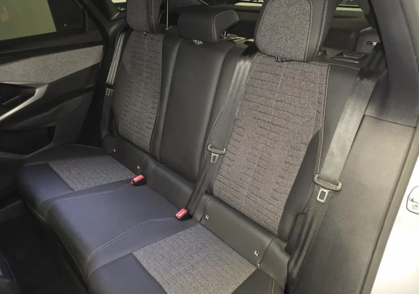 Vue intérieure du siège arrière du Peugeot 3008 gris, avec sellerie tissu et cuir noir, ceintures de sécurité et appuie-têtes visibles.