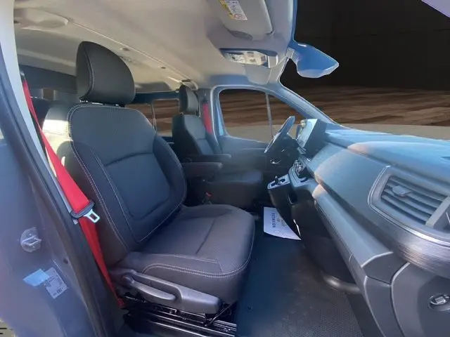 Vue intérieure côté conducteur du Renault Trafic Cabine Approfondie gris urbain, sièges noirs et tableau de bord moderne.