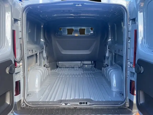 Vue arrière ouverte du Renault Trafic Cabine Approfondie gris urbain montrant l'espace de chargement vide et la cloison intérieure.