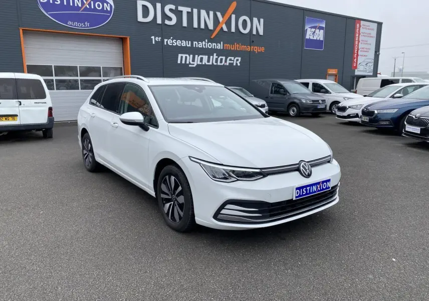Volkswagen Golf SW blanc oryx vue 3/4 avant droit, avec vitres arrière surteintées et jantes spécifiques.