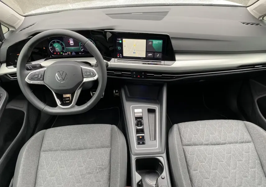 Vue intérieure avant du tableau de bord et volant Volkswagen Golf 2024 avec écran tactile et combiné digital.