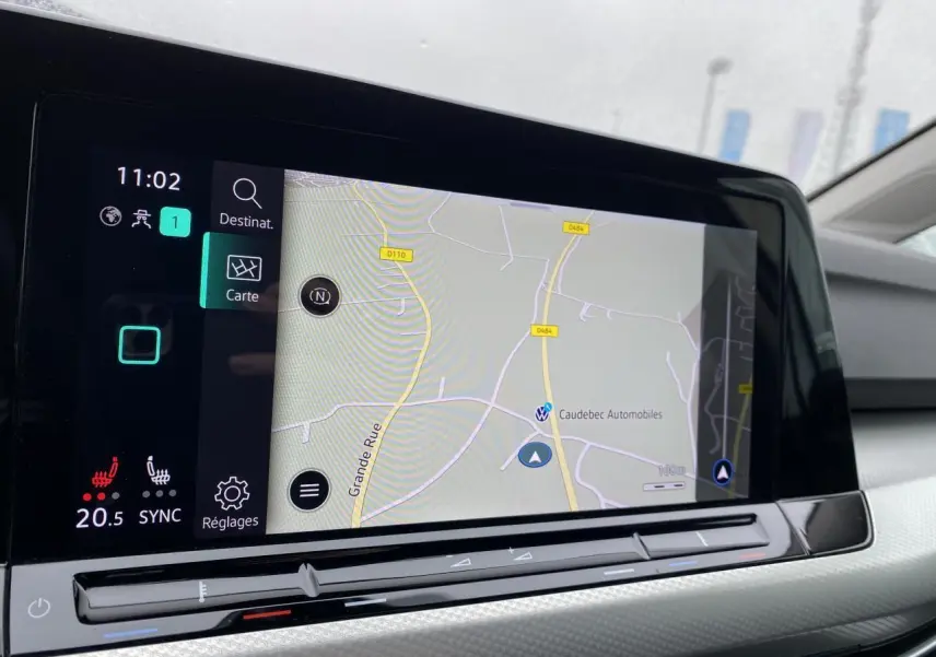 Écran tactile central affichant la navigation et commandes climatisation dans une Volkswagen Golf SW 2024 blanc oryx.