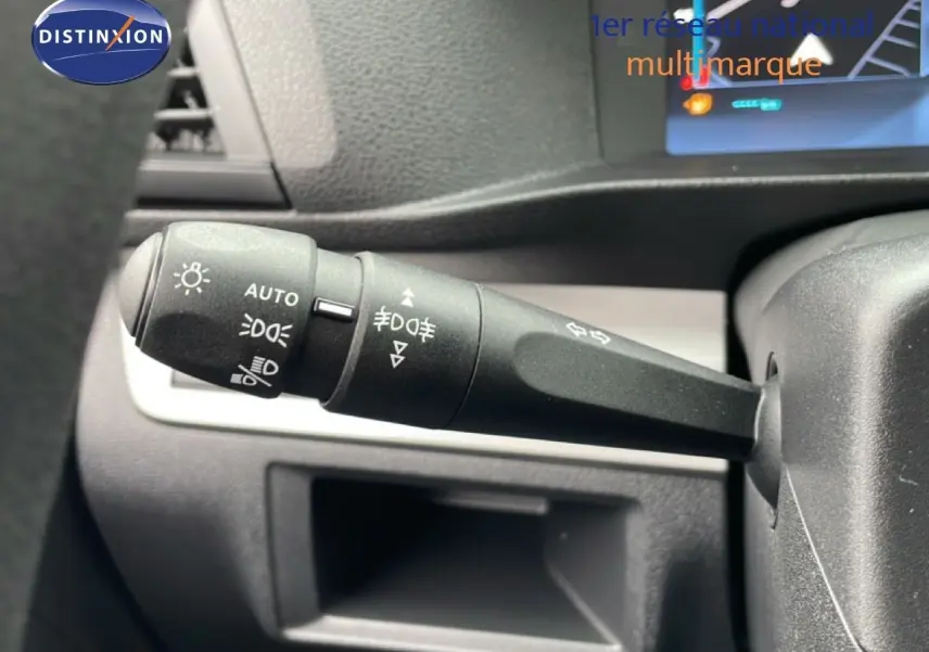 Gros plan sur la manette de commande d'éclairage à gauche du volant dans un Citroën Jumpy gris Artense 2025.