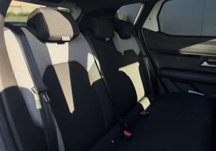 Vue latérale intérieure du siège arrière noir et gris du Dacia Duster 2026, avec ceinture de sécurité et appuie-têtes visibles.