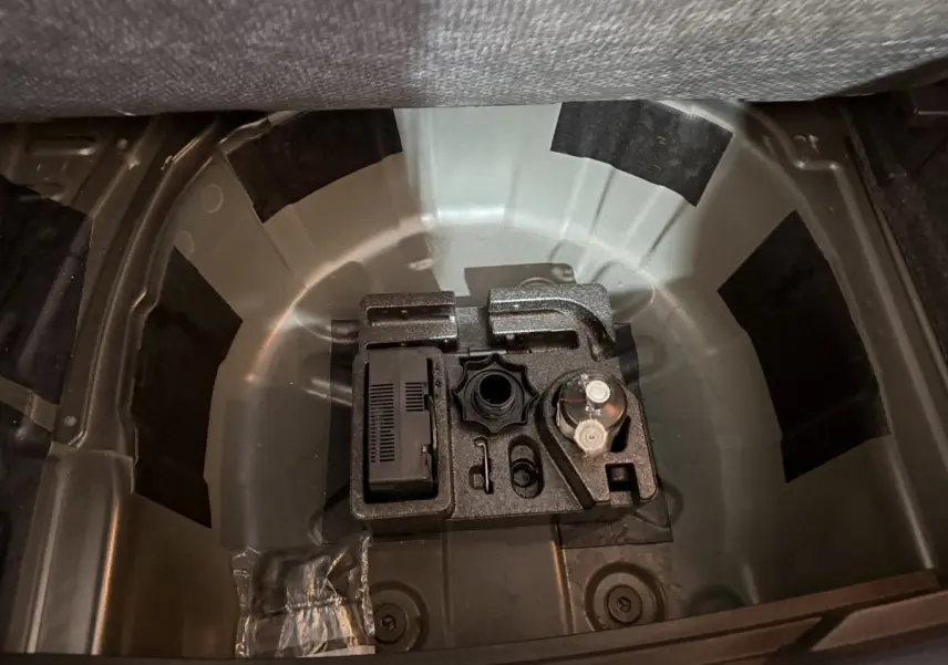 Vue plongeante sur le coffre ouvert d'une SEAT Ibiza noire 2024, montrant le rangement sous la tablette arrière.