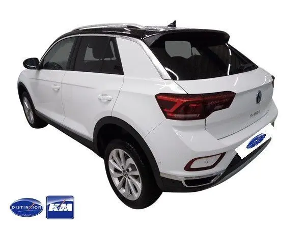 Vue 3/4 arrière droite d'un Volkswagen T-Roc blanc avec toit noir, feux arrière LED et jantes alliage 17 pouces.