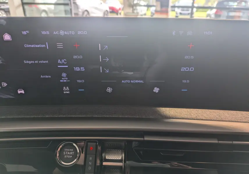 Écran tactile du tableau de bord du Peugeot 5008 hybride 2025 affichant les réglages de climatisation et la commande de boîte automatique.