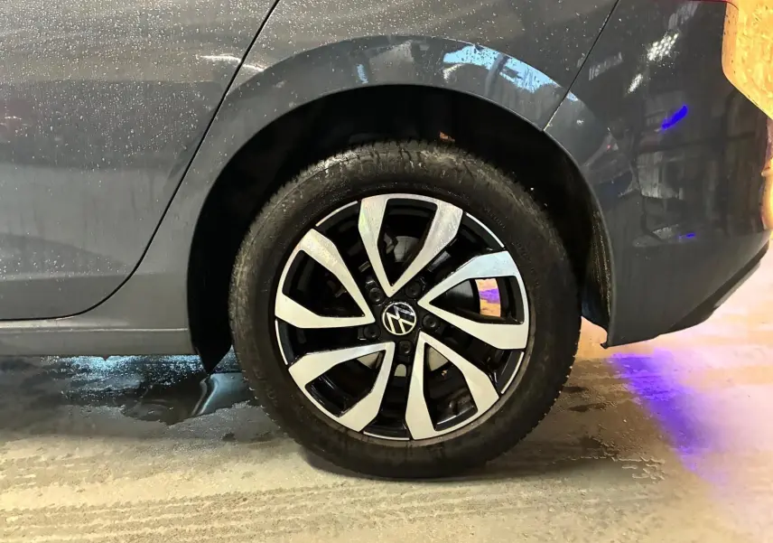 Gros plan sur la roue arrière droite d'une Volkswagen Golf gris métallisé avec jante alliage au design moderne.