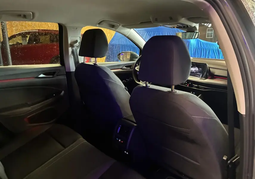 Vue intérieure arrière de la Volkswagen Golf 1.5 eTSI 130 DSG7 Active 2022, sièges tissu noir et tableau de bord visible.