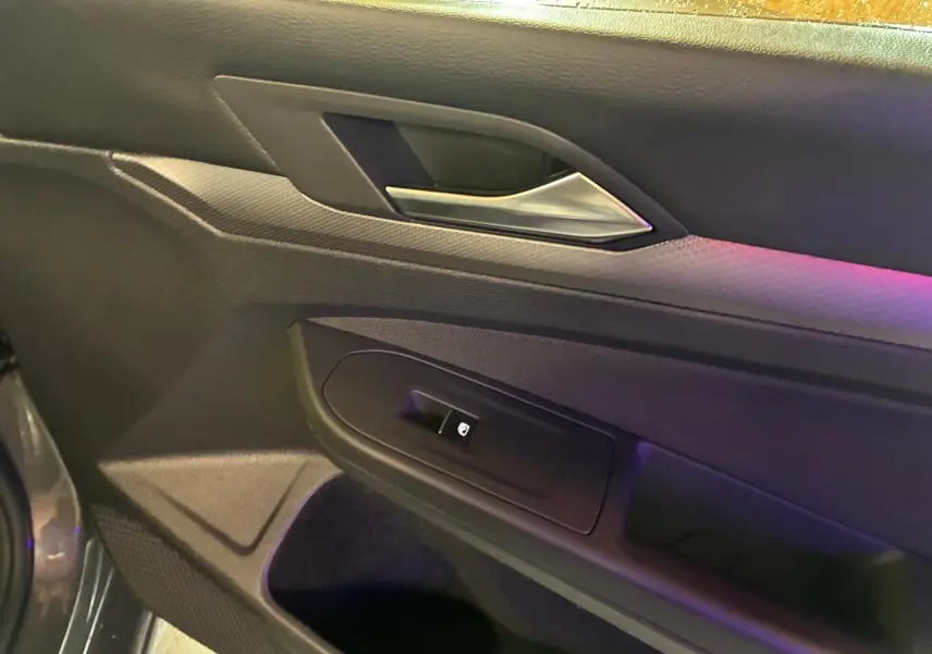 Détail de la porte côté gauche d’une Volkswagen Golf gris 1.5 eTSI 130 DSG7 Active avec commande de vitre électrique.