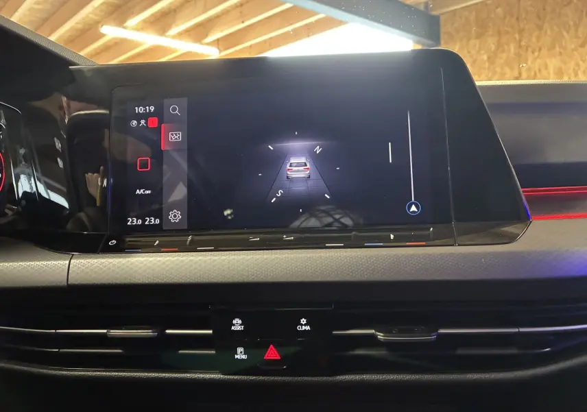 Vue rapprochée de l’écran tactile central de la Volkswagen Golf gris 2022, affichant la navigation et la climatisation.