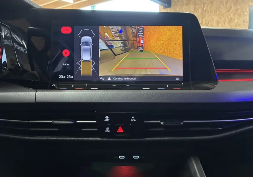 Vue rapprochée de l'écran multimédia de la Volkswagen Golf 1.5 eTSI 130 DSG7 Active 2022, affichant la caméra de recul et les capteurs de stationnement.