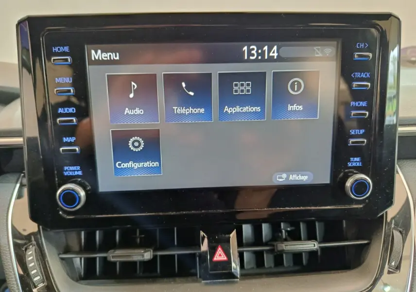 Écran tactile central de la Toyota Corolla Hybride 122h Active 2020 avec menu principal et commandes autour.