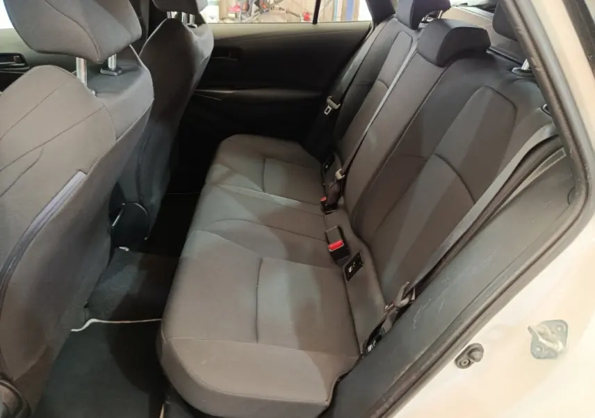 Vue intérieure côté droit montrant la banquette arrière noire de la Toyota Corolla Hybride 122h Active blanche de 2020.