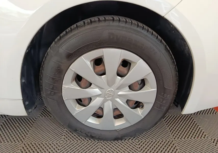 Gros plan sur la roue arrière droite blanche d'une Toyota Corolla Hybride 122h Active avec enjoliveur gris.