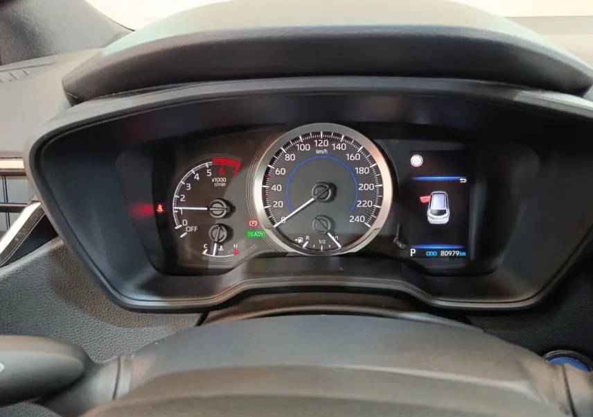 Vue rapprochée du tableau de bord de la Toyota Corolla Hybride 122h, affichage digital avec compteur et indicateurs.