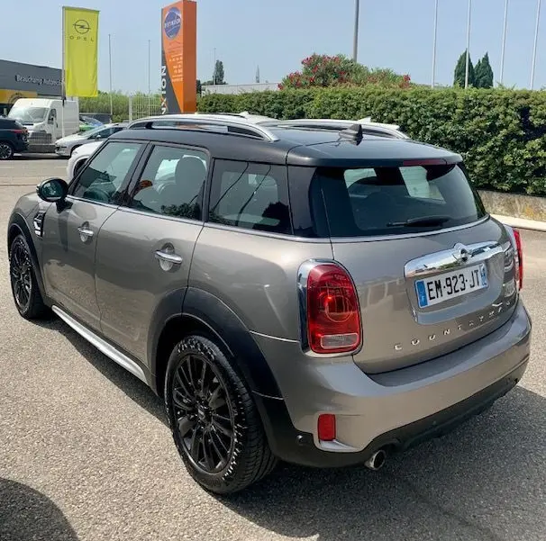 Vue 3/4 arrière droite d'une MINI Countryman Cooper D 150ch gris 2017 avec toit noir et jantes noires.