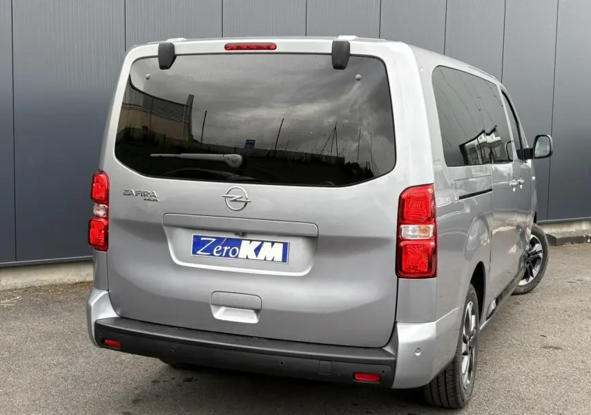 Vue 3/4 arrière droite de l'Opel Zafira Life XL gris Artense avec vitres teintées et feux arrière rouges.