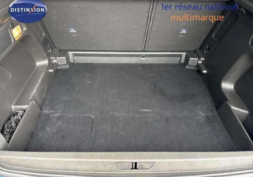 Coffre vide vu de l'arrière d'un Opel Grandland 2023 bleu Spektrum Metal avec revêtement noir et filet de rangement.