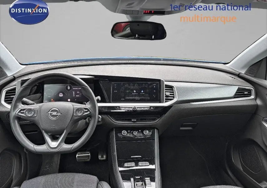 Intérieur avant de l'Opel Grandland 2023, tableau de bord moderne avec écran tactile et volant multifonction noir.