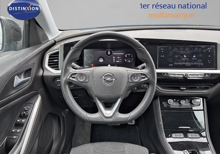 Vue intérieure frontale du poste de conduite de l'Opel Grandland 2023 avec tableau de bord numérique et volant cuir noir.