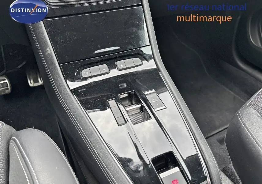 Gros plan sur la console centrale noire brillante de l'Opel Grandland 2023, avec levier de vitesses automatique et commandes.