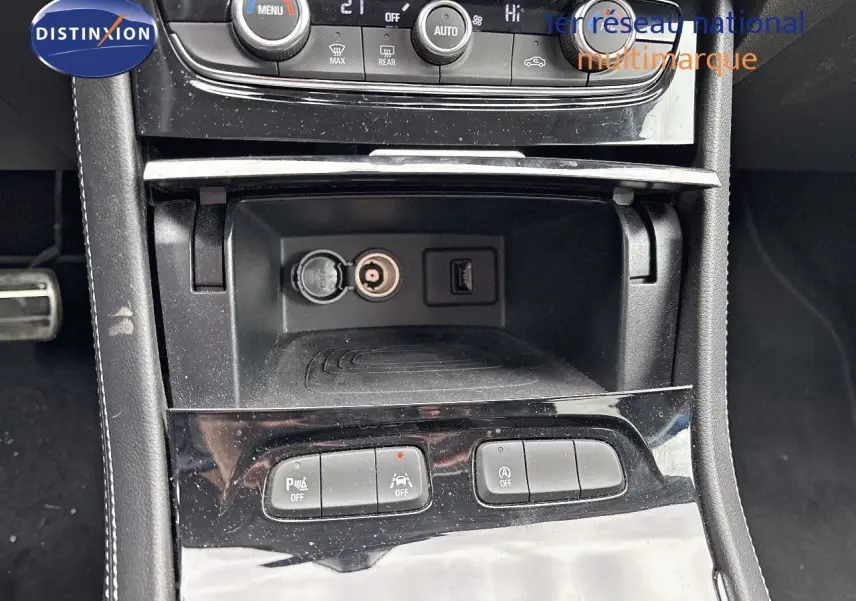 Vue rapprochée de la console centrale de l'Opel Grandland 2023, montrant les commandes de climatisation et prises USB et 12V.