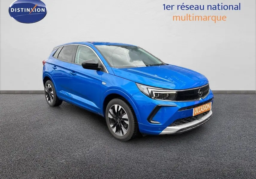 Opel Grandland 2023 bleu Spektrum métal en 3/4 avant droit avec calandre noire et jantes bicolores.