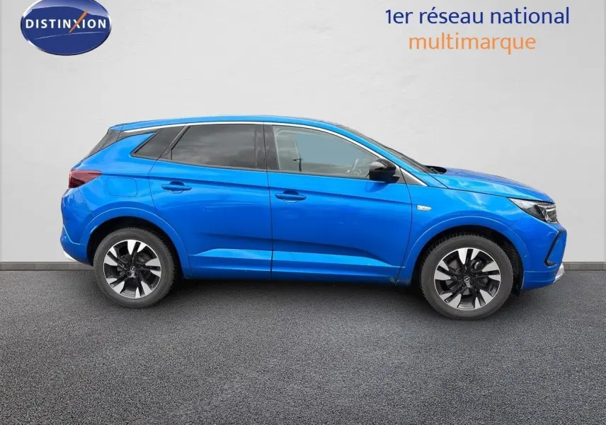 Profil droit d'un Opel Grandland 2023 bleu Spektrum Metal avec jantes alliage bicolores sur fond neutre.