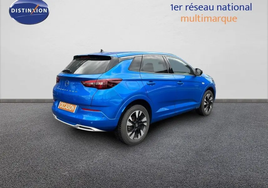 Opel Grandland bleu Spektrum métal vu en 3/4 arrière côté gauche avec jantes bi-ton et vitres teintées