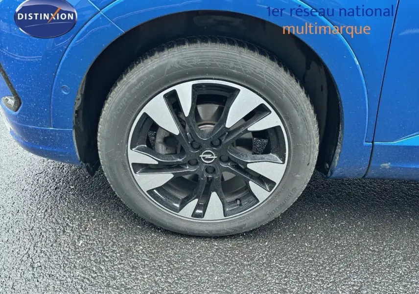 Gros plan sur la roue avant gauche de l'Opel Grandland bleu Spektrum Metal avec jante alliage bicolore.