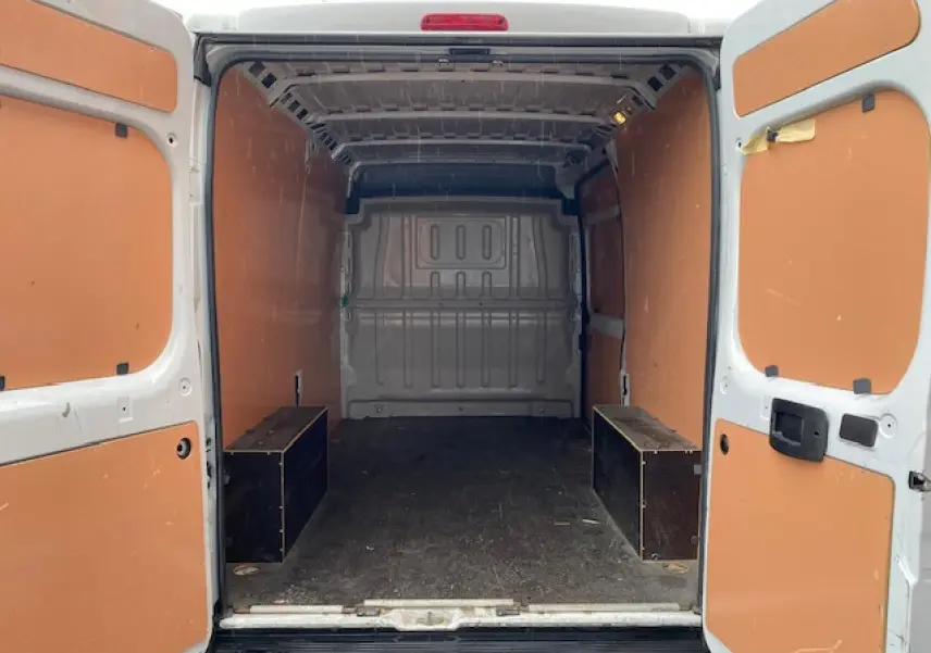 Vue arrière ouverte du fourgon blanc Opel Movano 2023 montrant l'intérieur avec plancher et parois en bois.