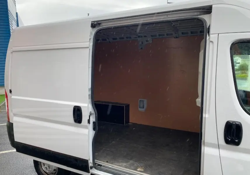 Vue latérale droite d’un Opel Movano Fourgon blanc 2023 avec porte coulissante ouverte sur l’espace de chargement vide.