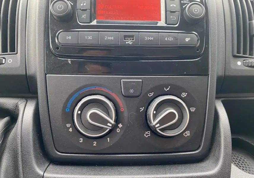 Vue rapprochée du tableau de bord de l'Opel Movano Fourgon 2023, montrant les commandes de climatisation manuelle.