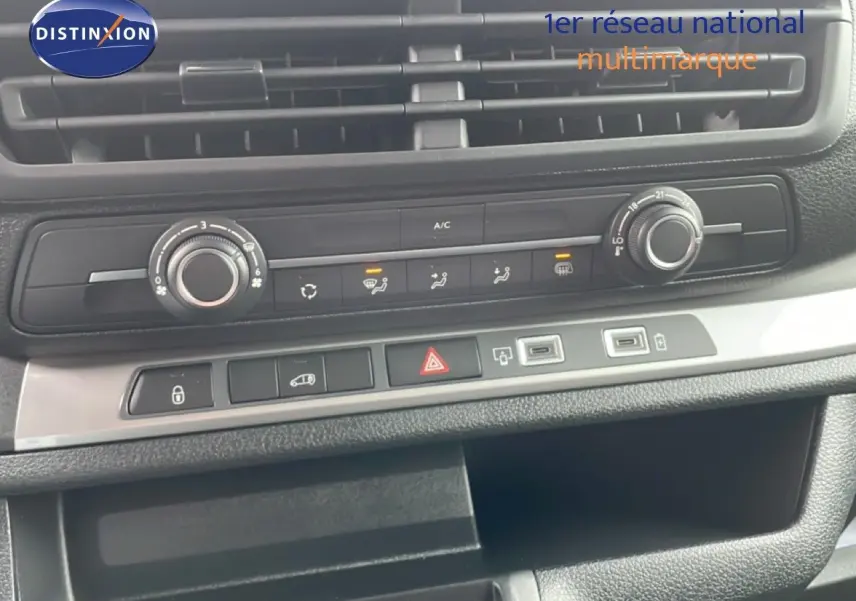 Vue rapprochée du tableau de bord du Citroën Jumpy gris, montrant les commandes de climatisation et les ports USB.