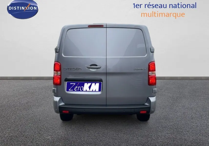 Vue arrière d’un Citroën Jumpy gris Artense métal, fourgon fermé avec feux rouges visibles et plaque Zero KM.