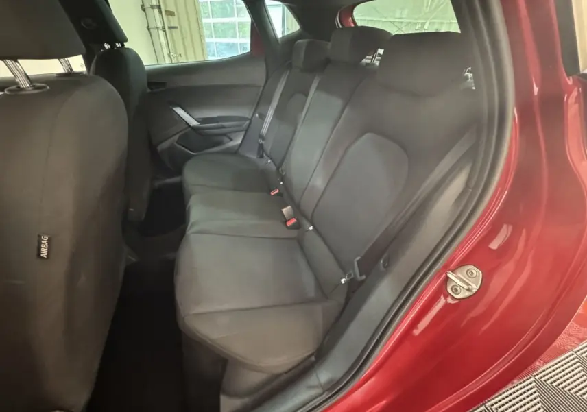 Vue côté droit de la banquette arrière noire de la SEAT Ibiza 1.0 TSI 110 FR rouge avec porte ouverte.