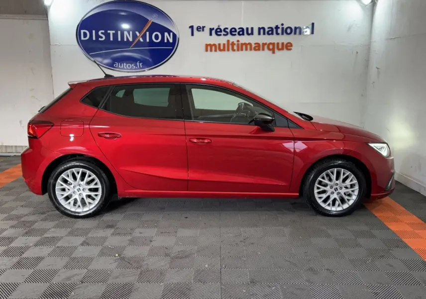Profil côté gauche de la SEAT Ibiza 1.0 TSI 110 FR rouge 2024 avec jantes alliage et lignes dynamiques visibles.