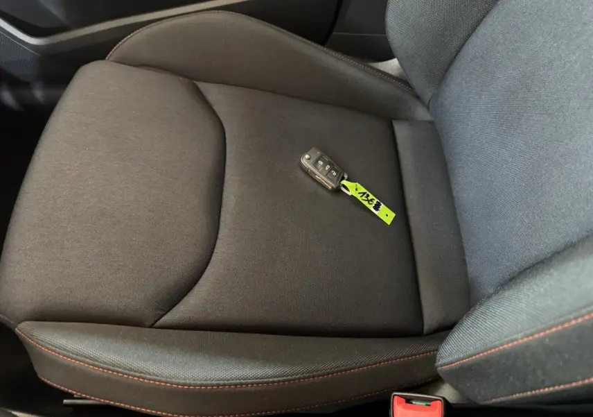 Gros plan sur le siège avant droit noir avec surpiqûres rouges et clé de voiture SEAT Ibiza posée dessus.