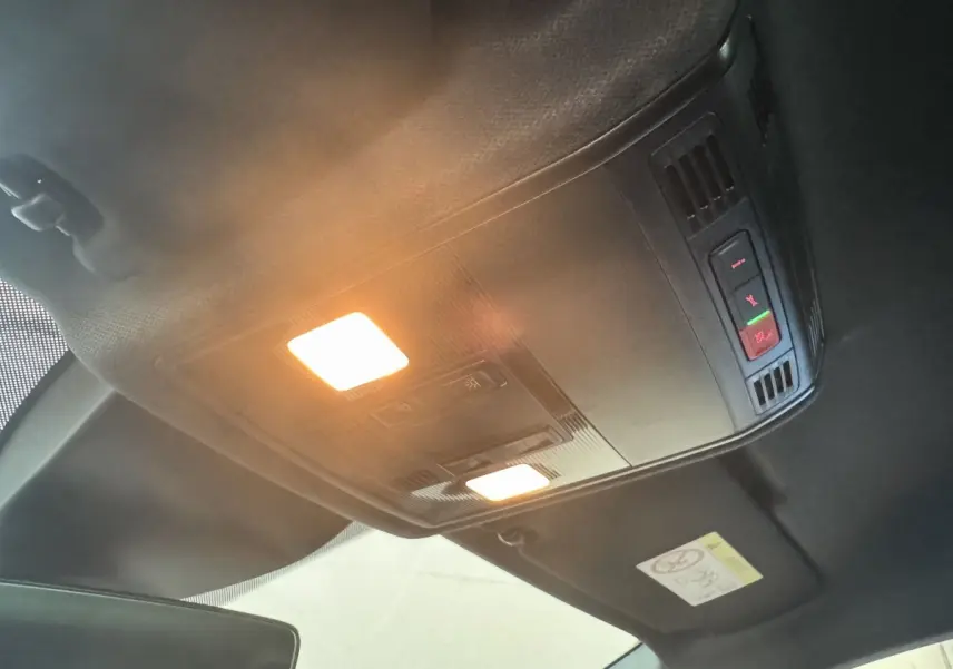 Plafonnier intérieur allumé avec commandes d’éclairage et d’alerte dans une SEAT Ibiza rouge 2024.