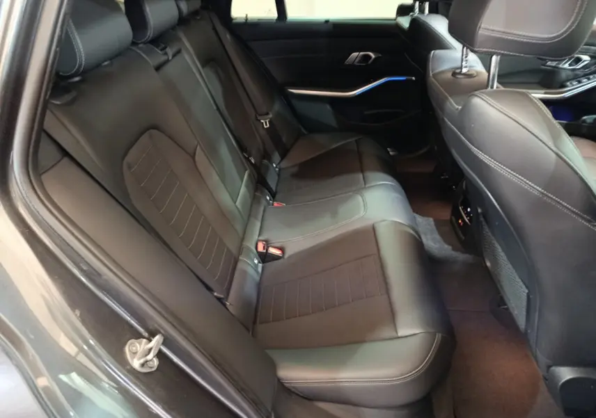Vue intérieure côté droit sur la banquette arrière en cuir noir de la BMW Série 3 318d Lounge 2022.