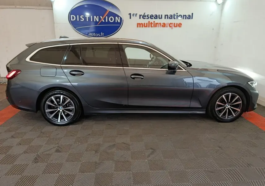 BMW Série 3 318d gris clair vue de profil côté droit en break avec jantes alliage et vitres teintées.