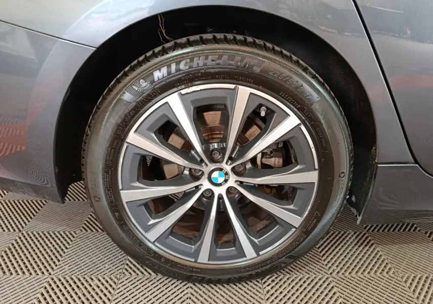 Gros plan sur la roue arrière droite gris clair d'une BMW Série 3 318d Lounge 2022 avec jante alliage et pneu Michelin.