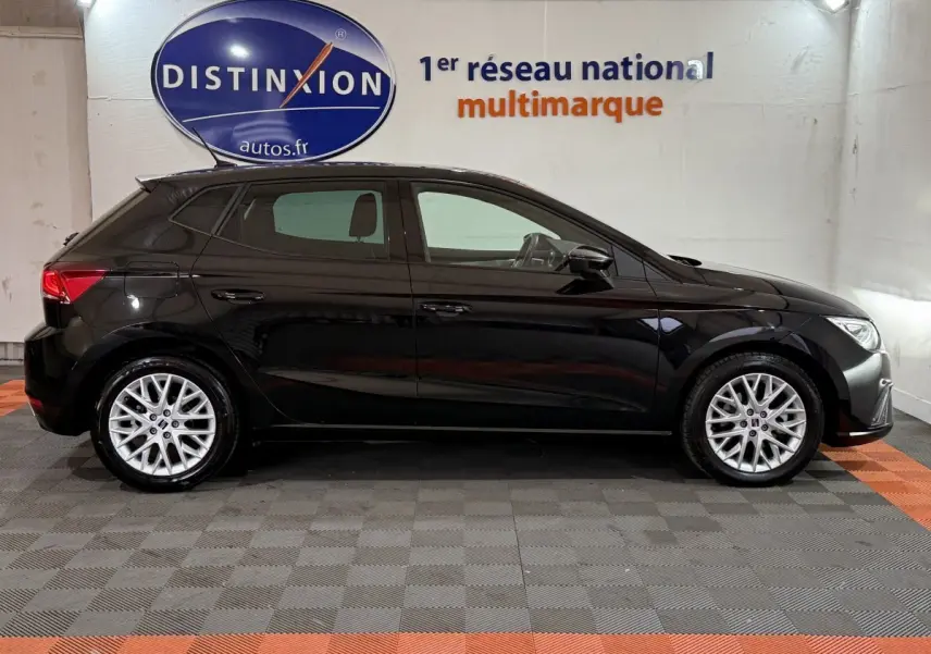 Profil côté gauche d'une SEAT Ibiza 1.0 TSI 110 FR noire, avec jantes alliage et intérieur visible en arrière-plan.