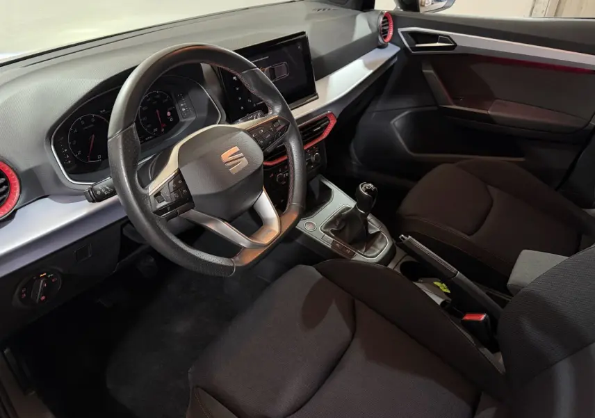 Vue intérieure côté conducteur de la SEAT Ibiza 1.0 TSI 110 FR 2024, volant cuir alu et écran tactile central.