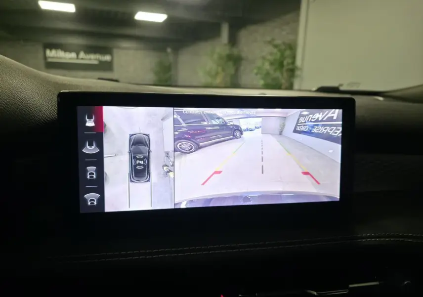 Écran tactile intérieur affichant la caméra 360° de l'Alfa Romeo Tonale rouge, vue arrière en parking intérieur.