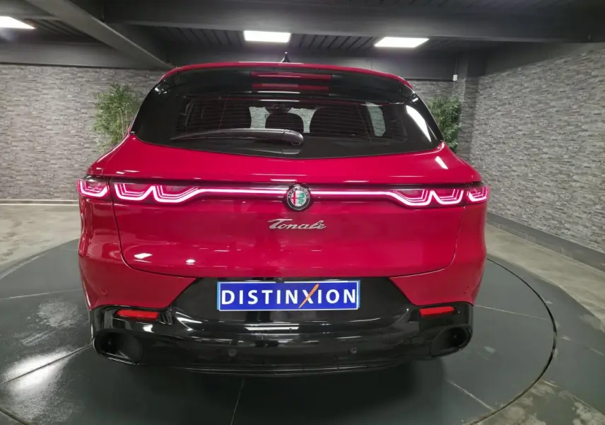Vue arrière d'une Alfa Romeo Tonale rouge avec feux LED distinctifs et diffuseur noir brillant.